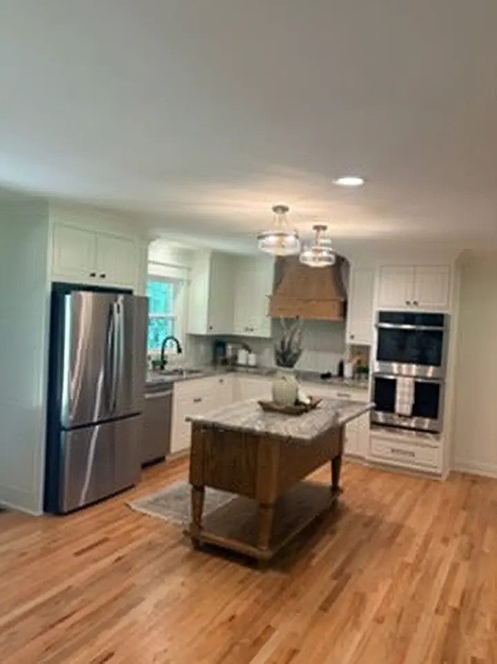 Kitchen remodel with a furniture-style island and white oak range hood