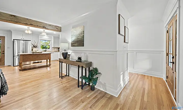 Open living space with wainscoting and a timber beam