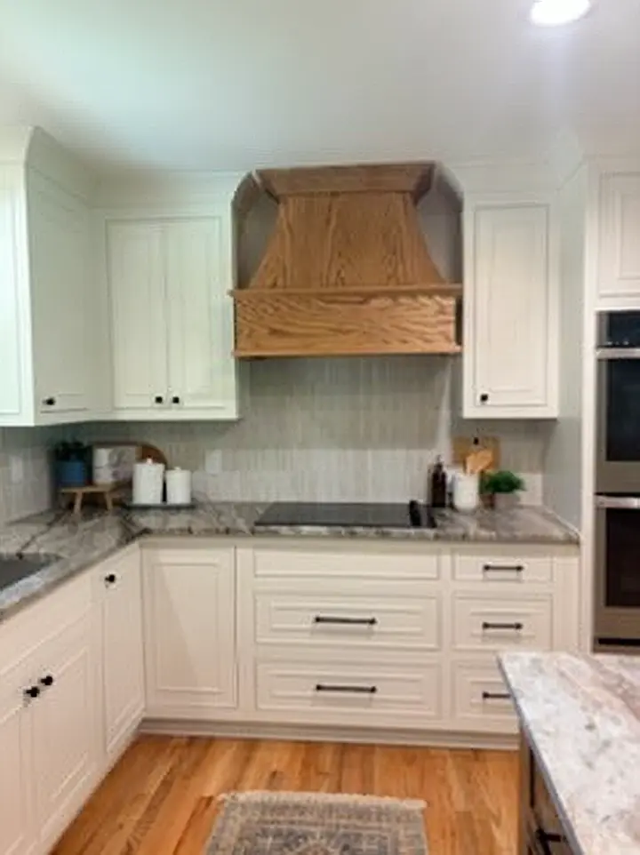 Custom white oak range hood and tile backsplash in a kitchen remodeled by Whitney Worley Construction
